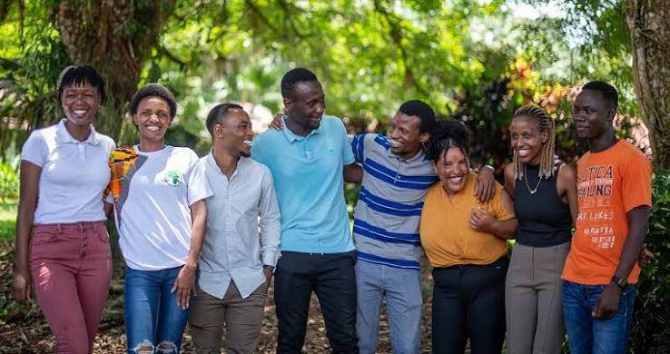 Young Africans standing arm in arm outdoors, smiling together